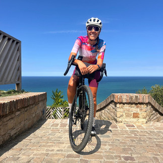 Mulher de bicicleta em frente ao mar