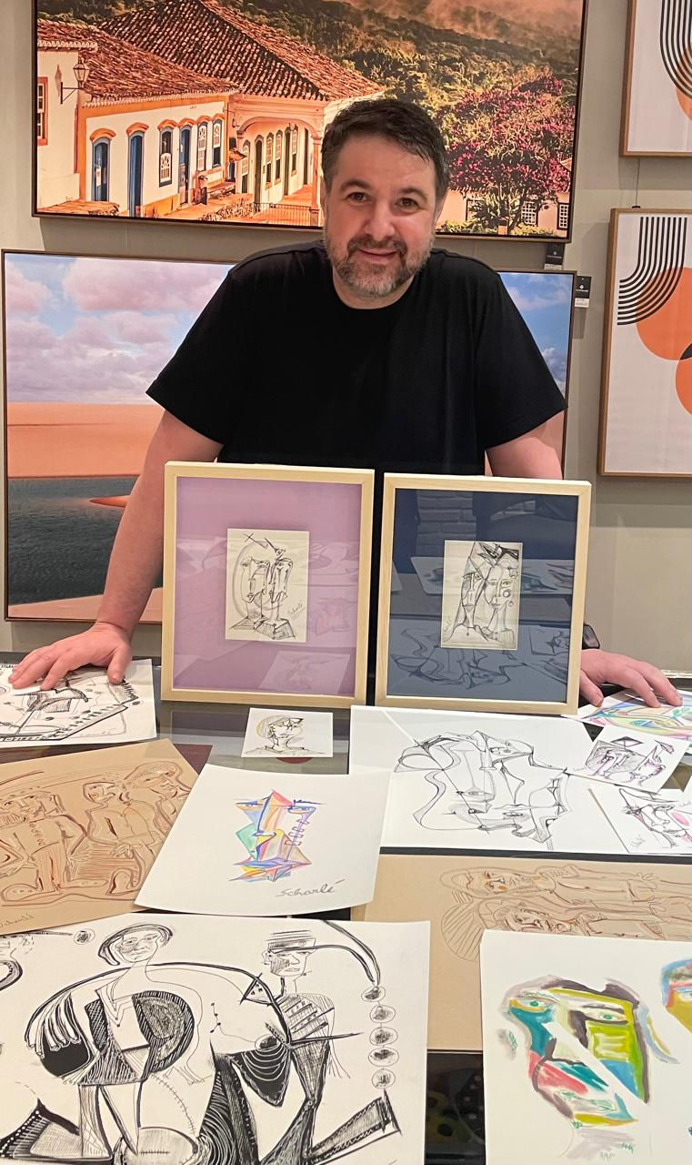 O empresário Fabiano Canton segura obras de arte de Joanna Scharlé, expostas na FastFrame do Ponteio Lar Shopping