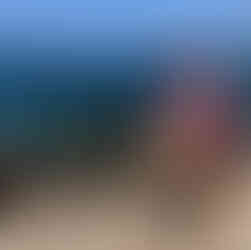 Mulher de bicicleta em frente ao mar