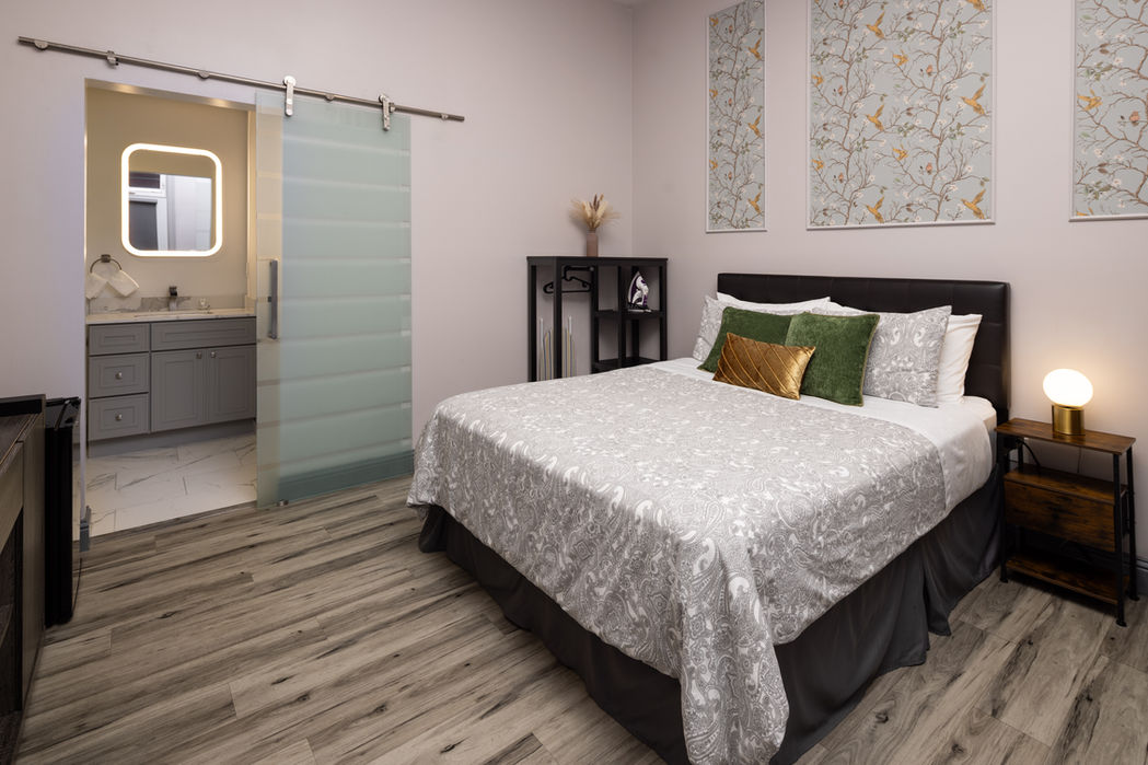 Bedroom with queen bed and sliding door to bathroom