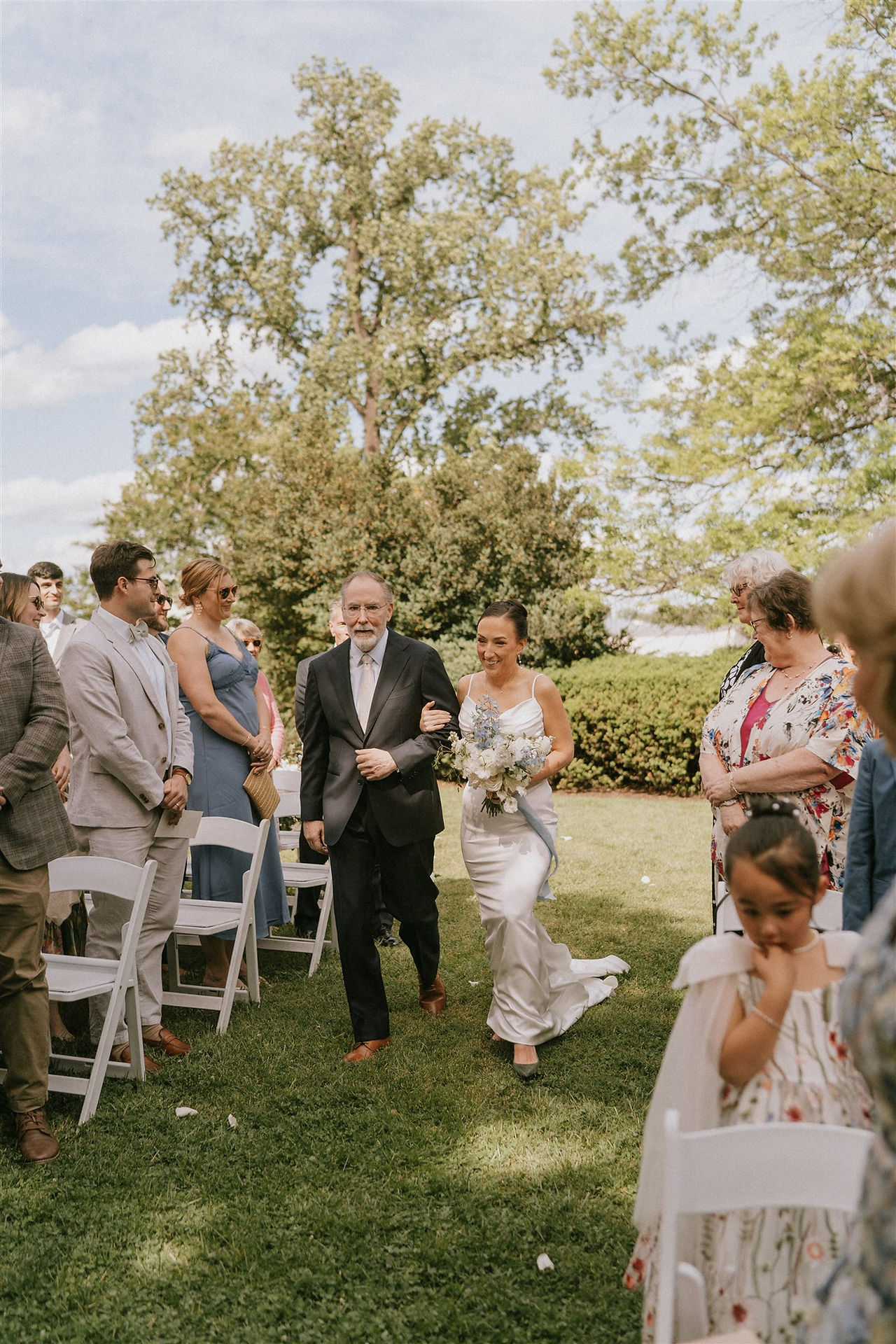 a bride and her father walk down the aisle 