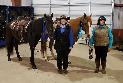 Two riders standing next to their horses in traditional show gear