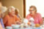 Residents sitting at dining table smiling