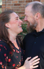 An adult couple looking at each other and laughing 