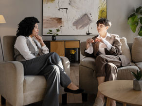 Two people from different backgrounds engaged in counselling conversation, demonstrating empathy across difference