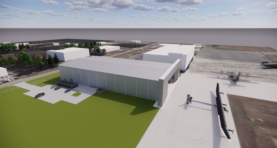 Large hangar building, aircraft on tarmac, industrial facility aerial view.