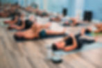 Group of people on mats practicing yoga in a studio at yoga sol
