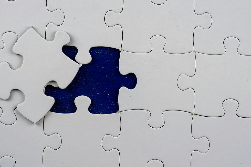 Photograph of a nearly completed white jigsaw puzzle with one piece missing, revealing a dark blue background beneath. The puzzle piece to be placed is held above the empty space, highlighting the final step to complete the puzzle. AI for brand positioning.