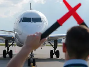 Marshal de aeropuerto dando señales a avión