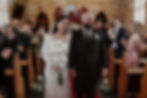 A newly married couple walking back down the aisle