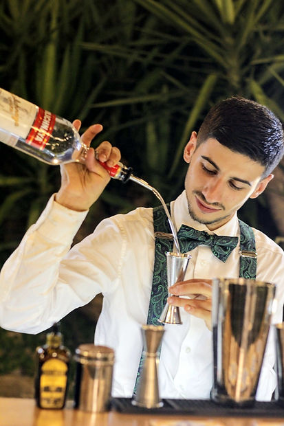 Bartender esperto in mixology durante la preparazione di cocktail premium per evento a Caserta.