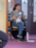 Emilia sitting on a chair holding a baby doll teaching an antenatal class