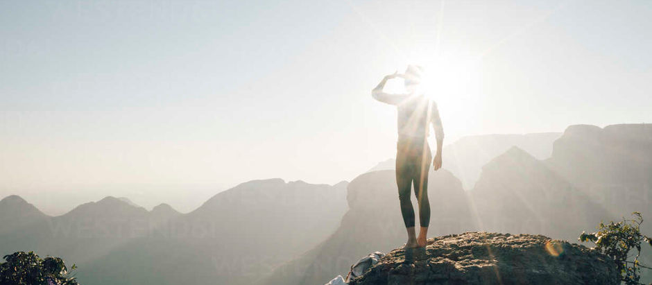 Femme de dos face à un paysage naturel, symbole de transformation intérieure et de retour à soi