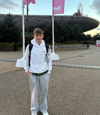 boy standing in front of london aquatics centre