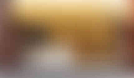 A store front with glass panes that say burger, fries, sundaes and a yellow overhang that says supernova