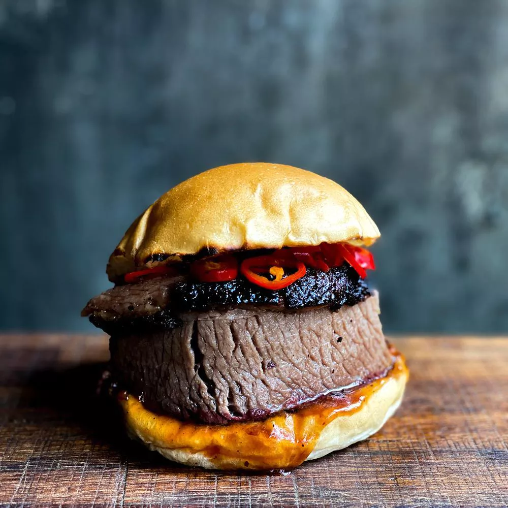 Picture of a brisket burger on a wooden table