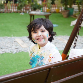 Little boy sitting on a swing wearing a white kurta for an Eid event in London, Ontario, festive celebration moment
