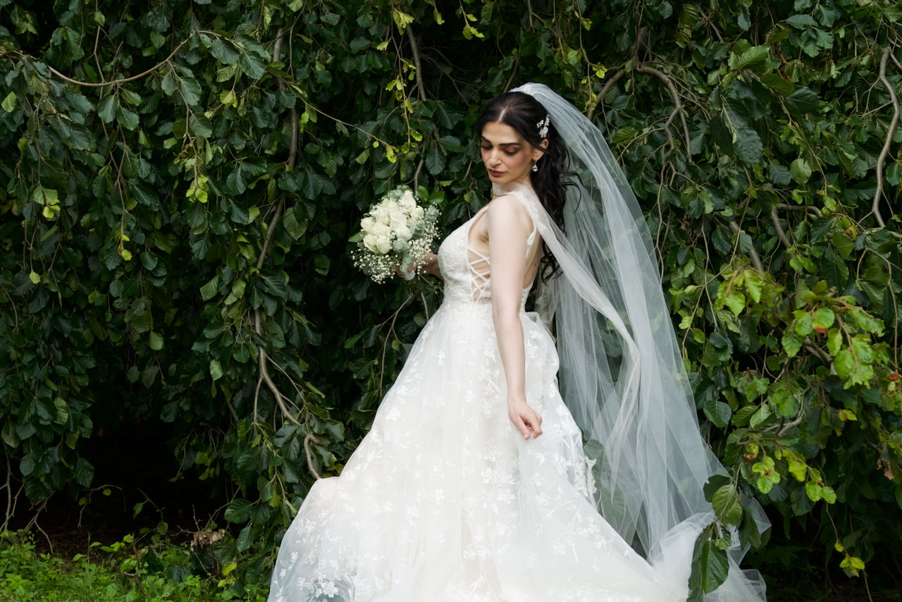 model wearing bridal long outfit holding flower bouquet  posting for the shoot at spring bank london ontario 