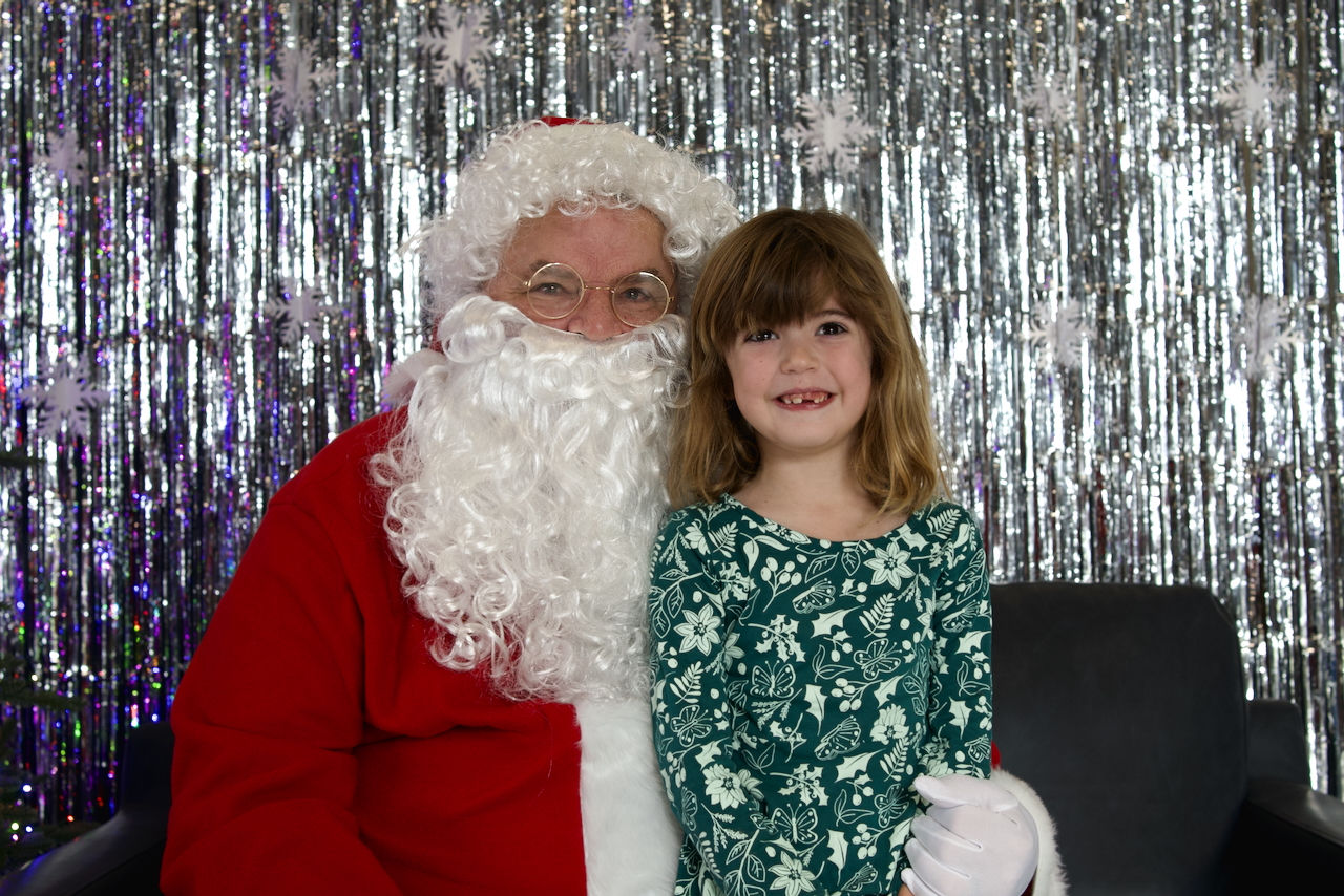 ittle child excitedly sitting with Santa and getting their photo taken at Winter Wonderland event at Humane Society London & Middlesex in London Ontario