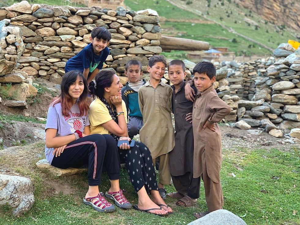 Personal moment in Hunza, Pakistan with my niece and local children, sitting together, chatting and laughing, capturing genuine smiles and joyful connection