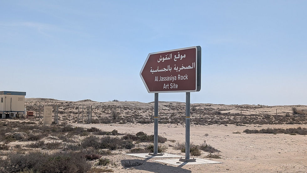 A sign pointing the way to the Al Jassasiya Rock Art Site.