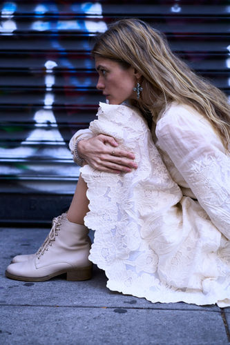 Model headshot, cool sitting pose, urban NYC background, contemporary portrait photography.