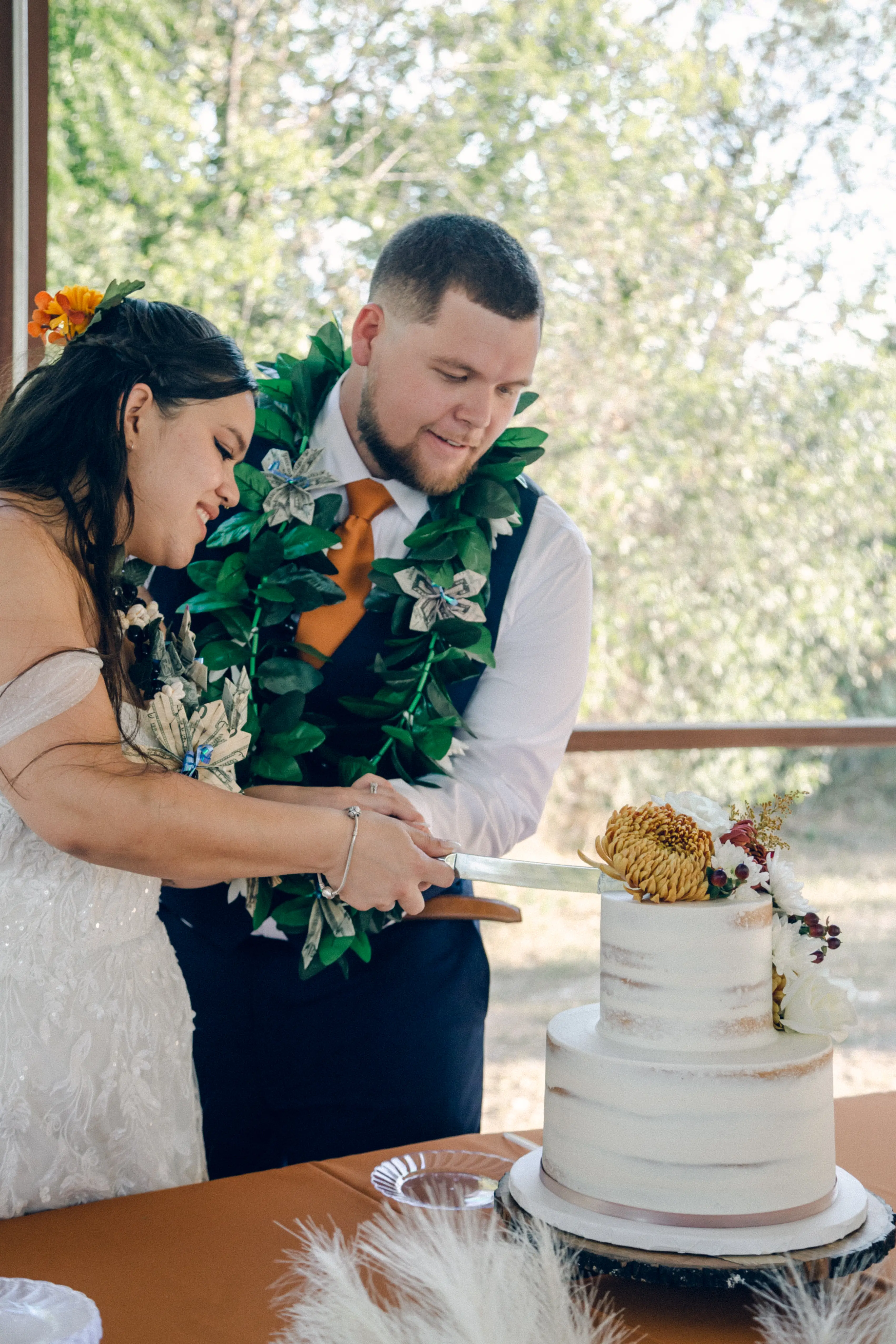 a bride and grrom cut their wedding cake during their reception at hidden creek at stonehaus