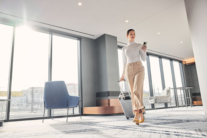 MX23_LIFESTYLE_HOSP DC female walking-to-room checking-phone lo-angle.jpg