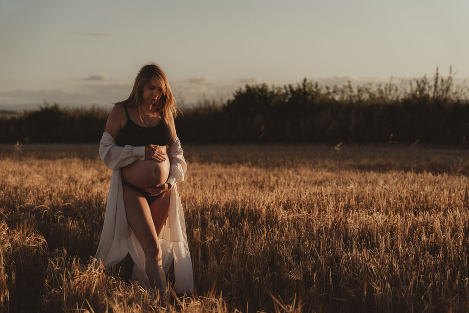 Maternity photography walking through golden fields 