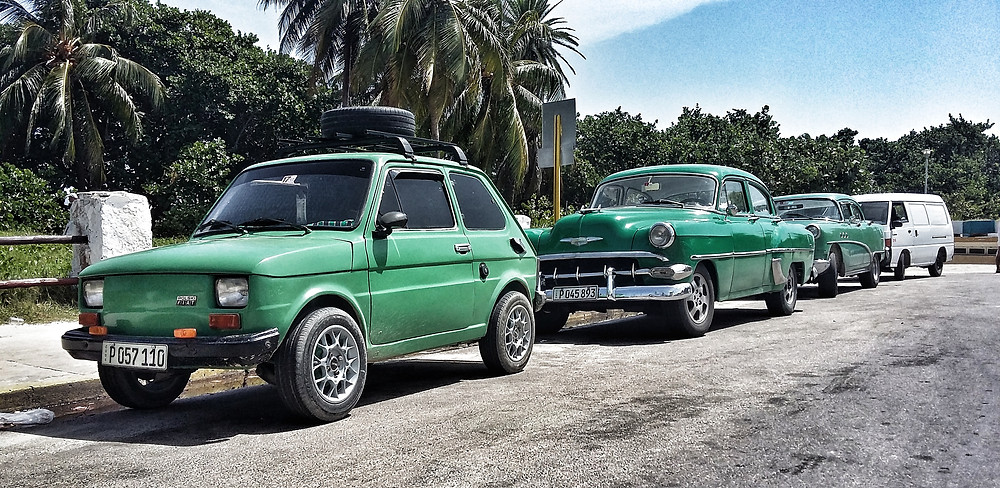 Modified green Fiat 126 in Cuba, with classic Chevrolets