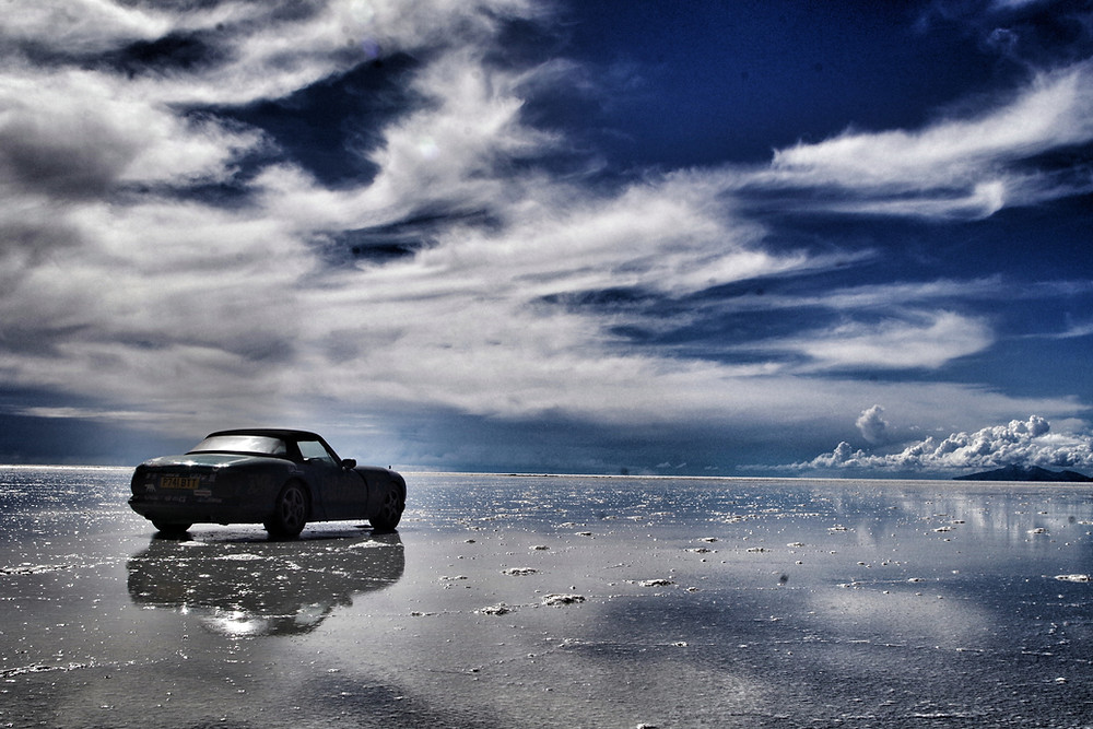 TVR Chimaera on Salar de Uyuni Salt flats in rainy season, Bolivia. Pan American overlanding adventure.