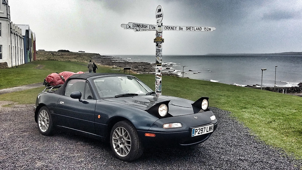 Mazda MX5 Mk1 at John o groats sign NC500 Scottish roadtrip