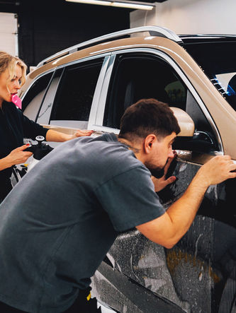 Inzken Skin staff installing a transparent, durable paint protection film (PPF) to safeguard the vehicle’s paint from scratches, chips, and UV damage.