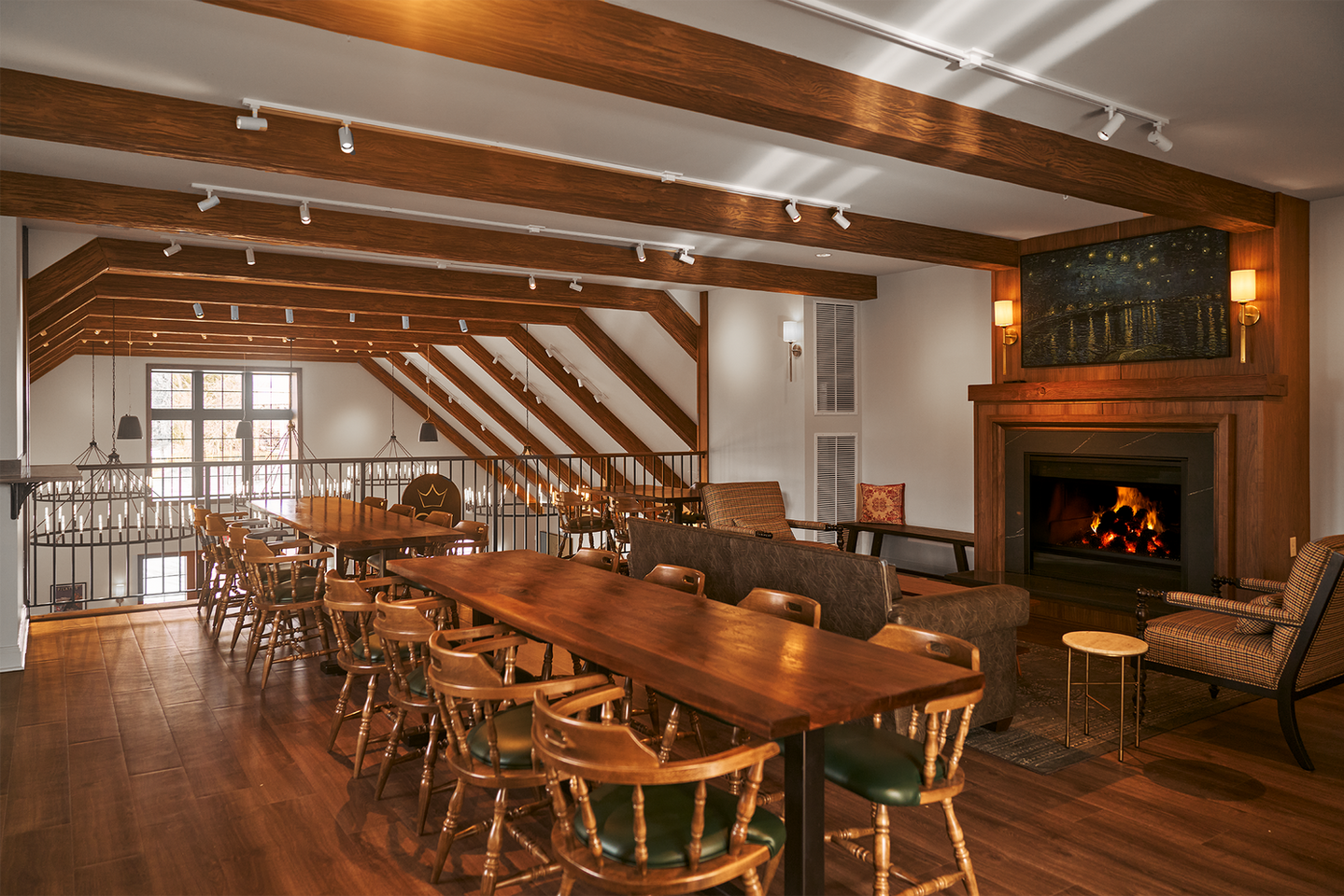 View of the upstairs loft private event space with fireplace, bierhall tables and sitting area at Great Heart Brewing.
