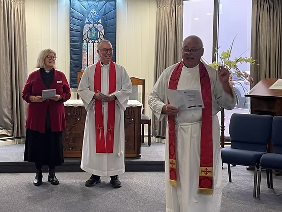 Three religious individuals leading a service in a chapel