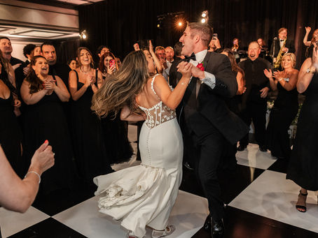 bride and groom dancing together at wedding after party with a large group of people