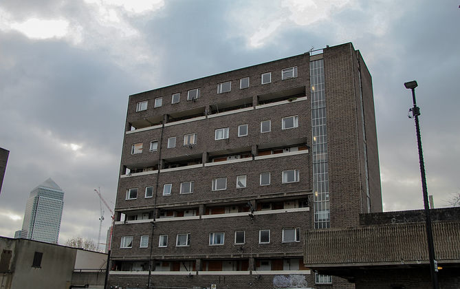 Residential apartment block in East London with the Canary Wharf skyline visible behind it.