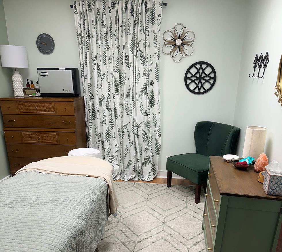 Wide-angle view of a quiet massage room with a treatment table and folded towels