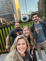 Several members of the ProSolve team pose for a selfie in front of a giant eyeball.