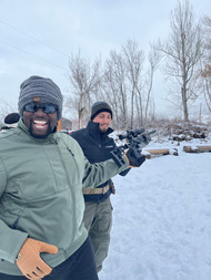 A picture of two ProSolve employees in winter gear, preparing to go airsofting.