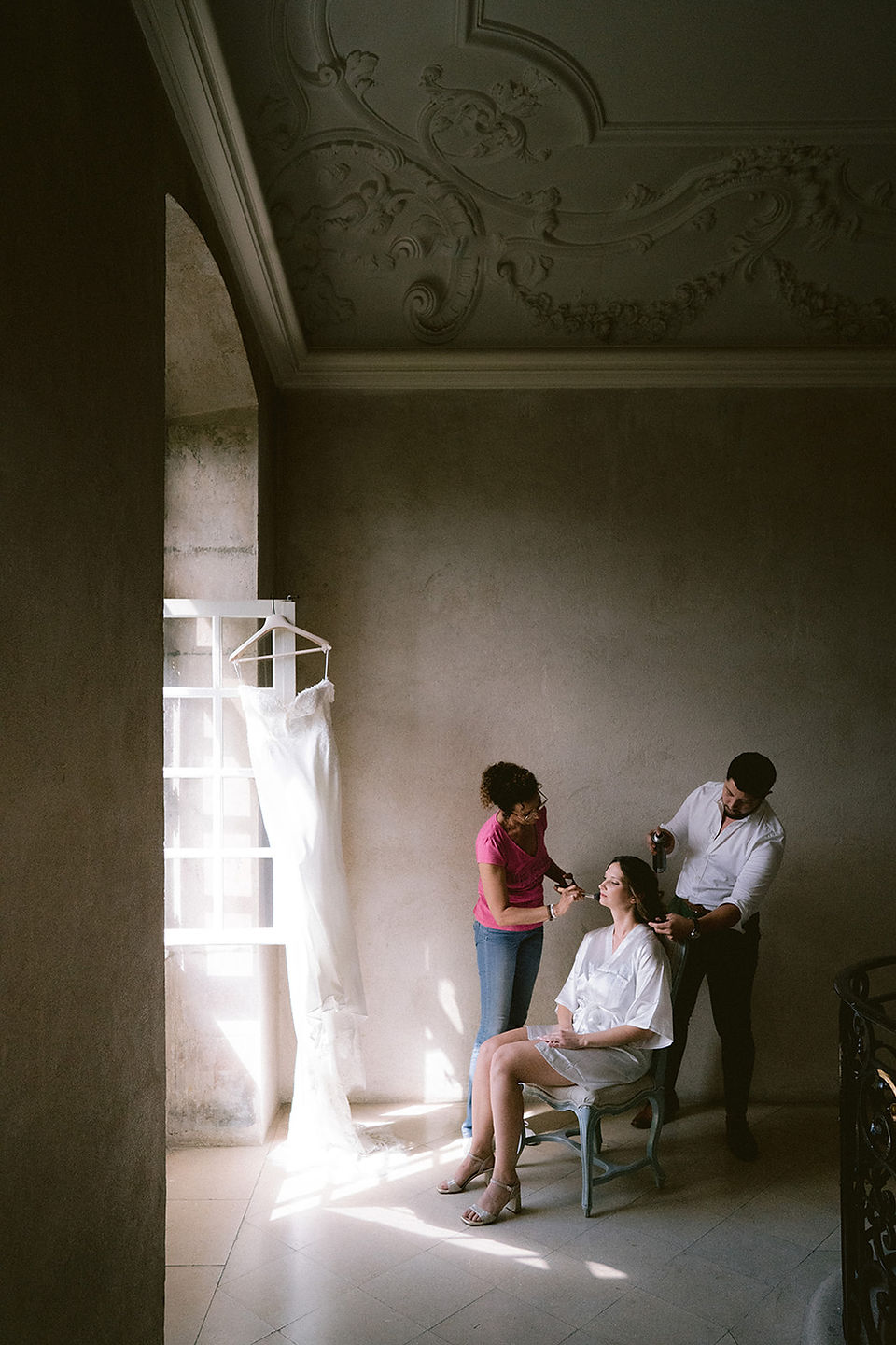 La future mariée se fait coiffer et maquiller devant une fenêtre de l'Abbaye des Prémontrés