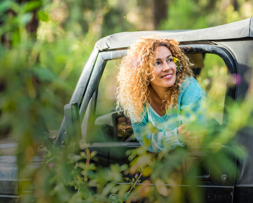 Smiling woman in jeep, enjoying nature