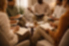 Diverse group of practitioners engaged in an experiential IFS workshop, taking notes and sharing insights in a collaborative learning environment