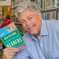 Joe French holding book in library