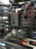 Tentacle Sync Box attached to camera equipment, demonstrating its use in ensuring precise timecode synchronization for professional sound recording setups.