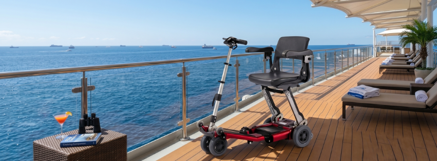 Luggie folding mobility scooter on a cruise ship deck overlooking the ocean.