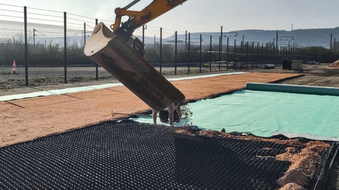 Using low-maintenance permeable surfaces that decontaminate hydrocarbons in an impound lot