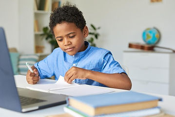 curious-black-schoolboy-with-curly-hair-sitting-table-checking-notes-workbook-while-doing_