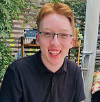 Smiling red-haired young man outdoors