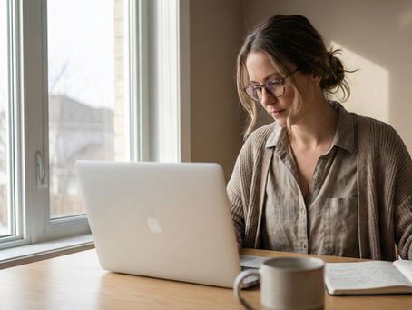 Calm marketing strategist reviewing notes beside a laptop in a natural light workspace, reflecting thoughtful and strategic decision making